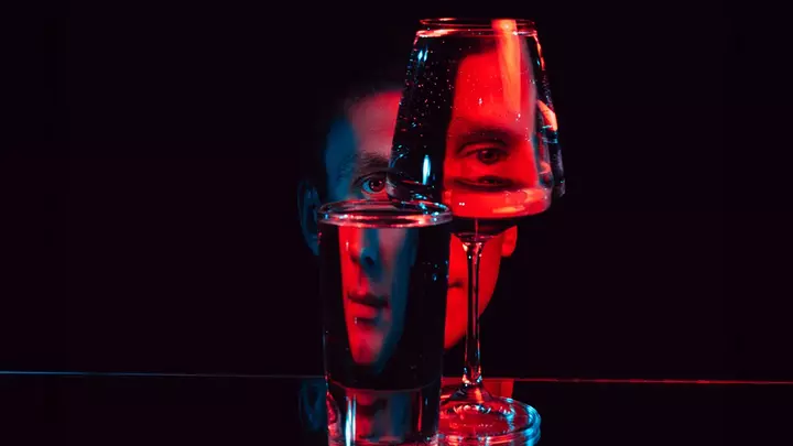 A face in red LED light broken visually by looking at it through glass